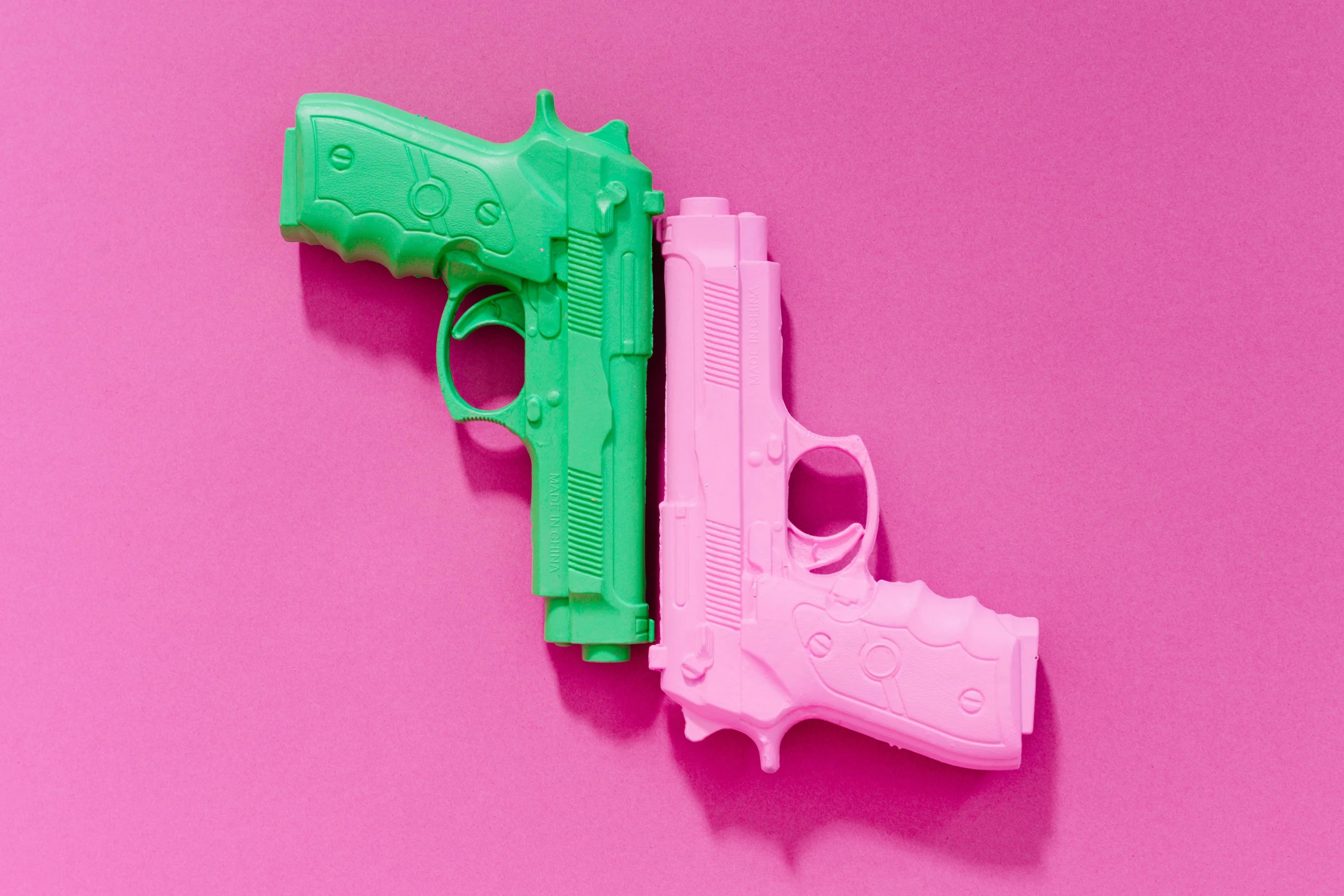 a pink and green toy gun on a pink background, inspired by Walther Jervolino, trending on pexels, pop art, no two bodies, close together, 3d printed, instagram picture