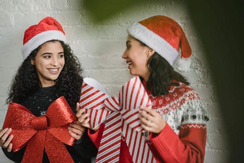 a couple of women standing next to each other, pexels contest winner, hurufiyya, wearing a santa hat, bows, avatar image, [ organic