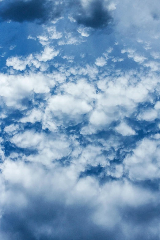 a plane flying through a cloudy blue sky, an album cover, inspired by Jan Rustem, unsplash, precisionism, extreme fluffy clouds, top down view, layered stratocumulus clouds, smiling in heaven