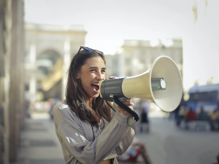 a woman with a megaphone on a city street, a photo, pexels contest winner, prompt young woman, avatar image, environmental, open mouth