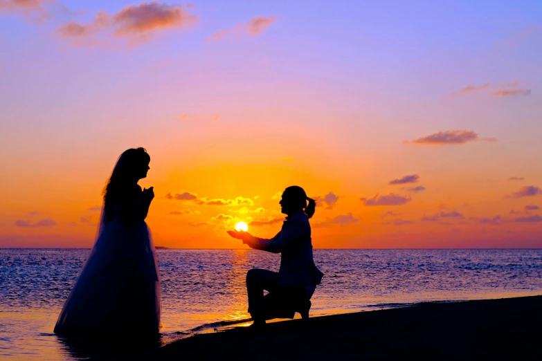 a couple of people standing on top of a beach, pexels contest winner, romanticism, man proposing his girlfriend, sunset halo around her head, wedding, kneeling