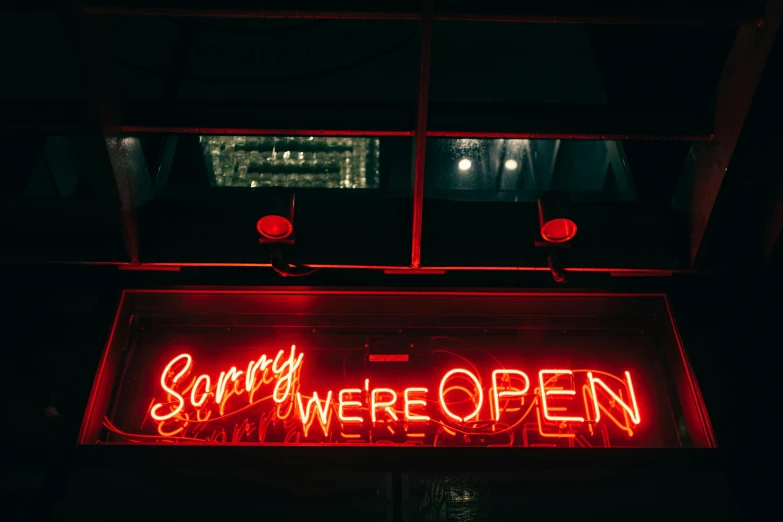 a neon sign that says sorry we're open, unsplash contest winner, 💋 💄 👠 👗, wrecked, during night, signed