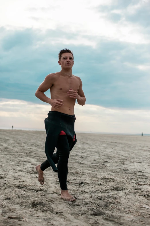 a man running on the beach on a cloudy day, by Jan Tengnagel, unsplash, renaissance, model with attractive body, low quality photo, official screenshot, working out in the field