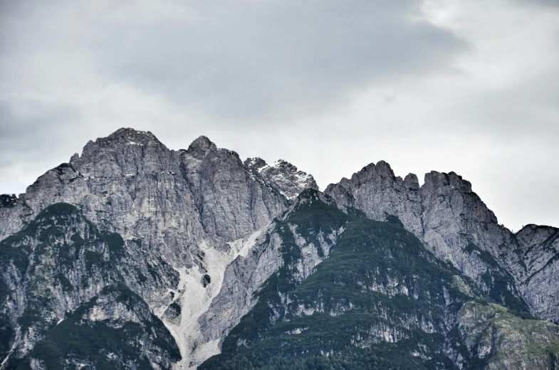 a couple of cows standing on top of a lush green field, by Tobias Stimmer, pexels contest winner, minimalism, snowy craggy sharp mountains, limestone, seen from a distance, herzog de meuron