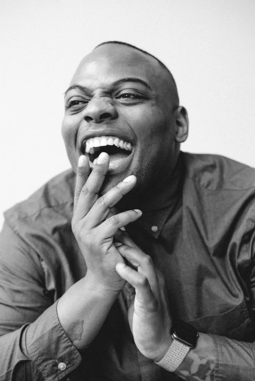 a black and white photo of a man with his mouth open, inspired by Richard Wright, dave chappelle, smiling and looking directly, kehinde wiley, smug smirk