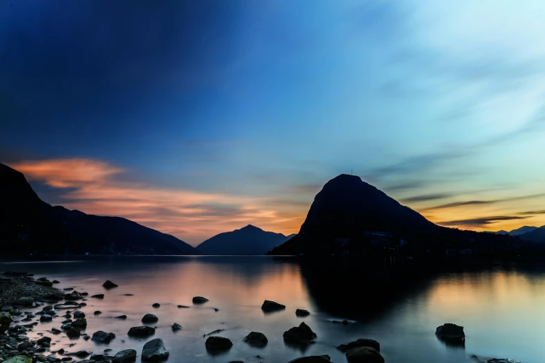 a large body of water surrounded by rocks, pexels contest winner, hudson river school, nightfall, lake kawaguchi, lake blue, youtube thumbnail