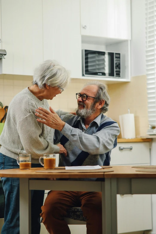 a man and a woman sitting at a kitchen table, by Elizabeth Durack, pexels contest winner, dancing with each other, healthcare, 4k), old man