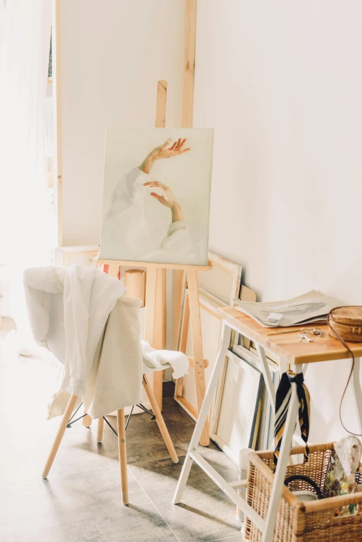 a living room filled with furniture and a painting, a minimalist painting, inspired by Juan Luna, trending on pexels, fashion studio, white table, easel, white paint