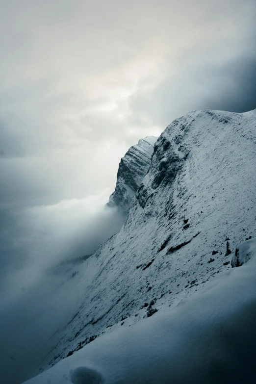 a mountain covered in snow under a cloudy sky, inspired by Michał Karcz, pexels contest winner, looking threatening, steep, photo realistic”