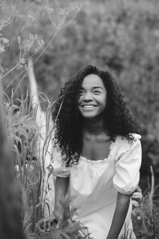 a black and white photo of a woman in a field, pexels contest winner, renaissance, smiling young woman, black teenage girl, curls, wearing white clothes