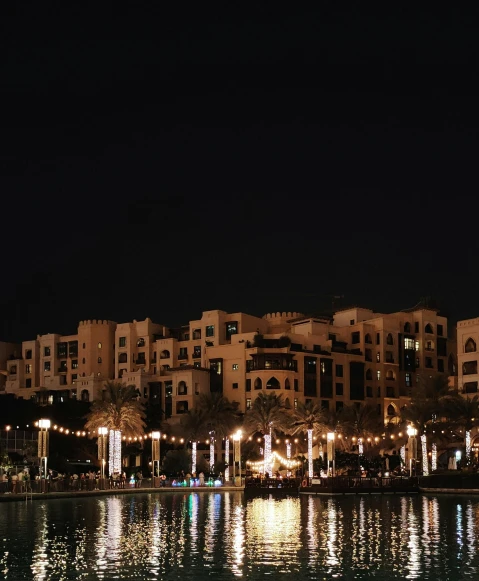 a large body of water with buildings in the background, by Benjamin Block, pexels contest winner, hurufiyya, arabian night, oasis infront, low quality photo, slightly tanned