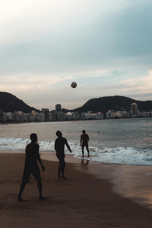 a group of people playing soccer on a beach, by Elsa Bleda, pexels contest winner, happening, city view, dan eder, brazilian, low quality photo