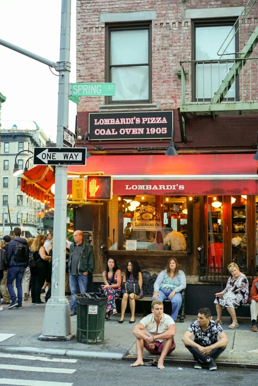 a group of people sitting on the side of a street, pizza in foreground, streets of new york, cinnabar, a quaint