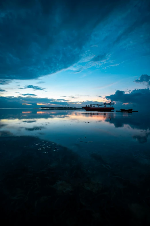 a boat floating on top of a body of water, by Daniel Seghers, unsplash, blue sunset, indonesia national geographic, slide show, reflect