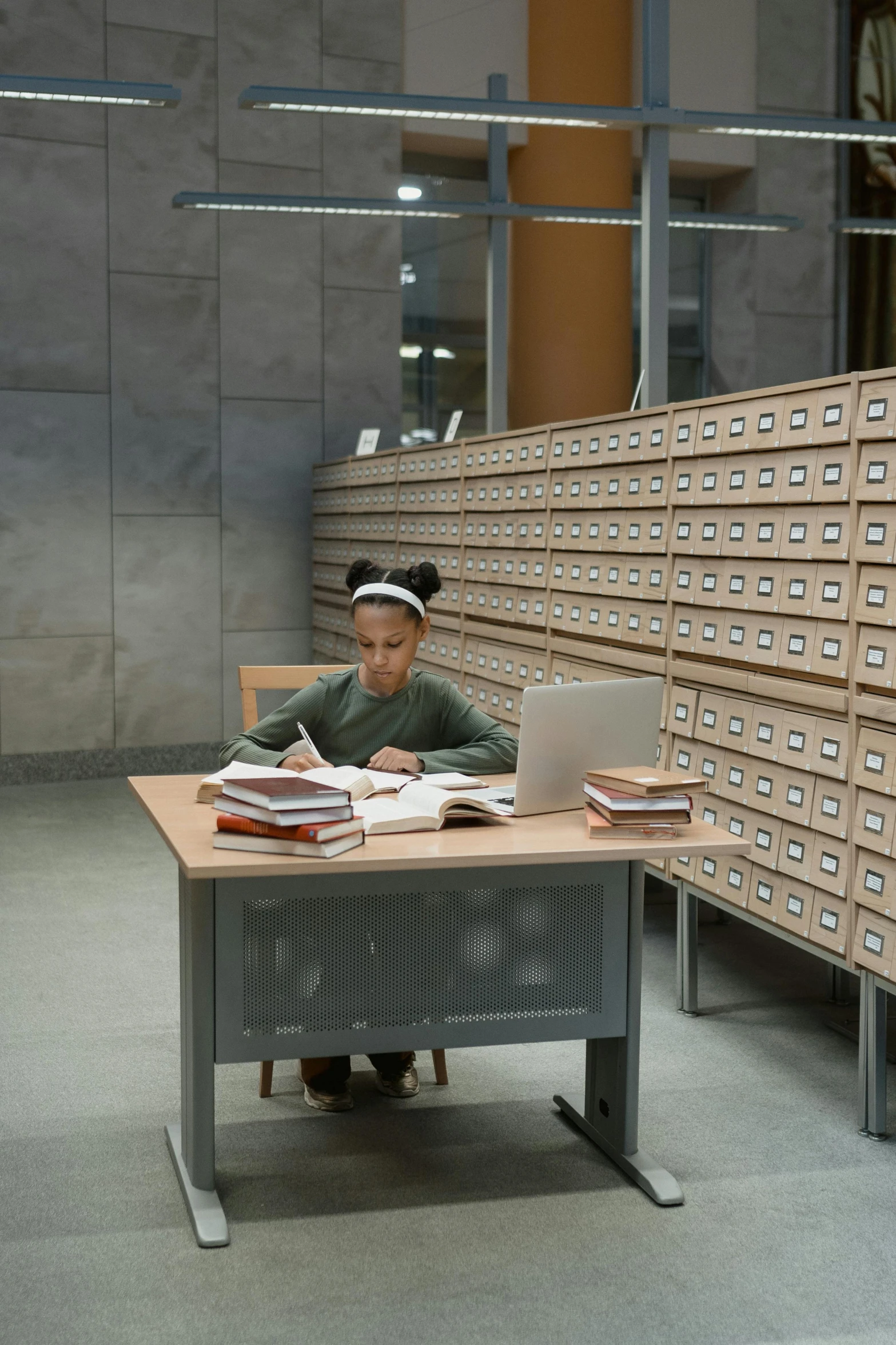 a person sitting at a desk with a laptop, an album cover, by Morris Kestelman, academic art, infinite library, set inside of the bank, photo of the girl, photographed for reuters