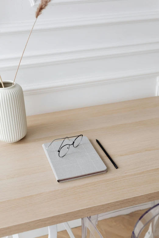 a white vase sitting on top of a wooden table, by Harvey Quaytman, trending on unsplash, notebook, dwell, swedish writing, thin linework