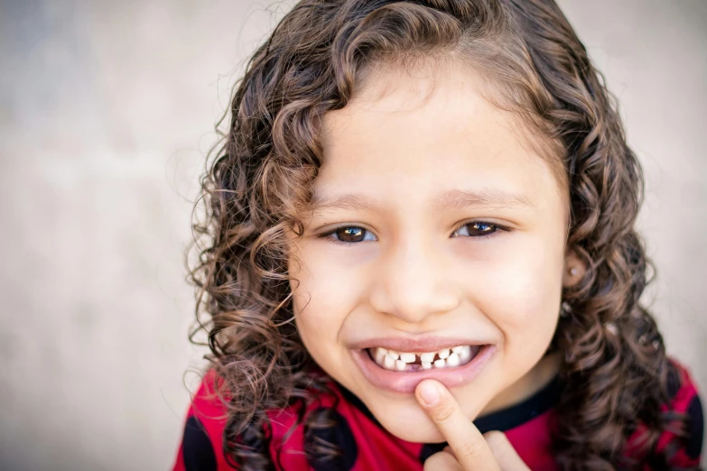 a close up of a child with a toothbrush, by Lilia Alvarado, pexels contest winner, dark short curly hair smiling, 15081959 21121991 01012000 4k, mixed race, crocodile - like teeth