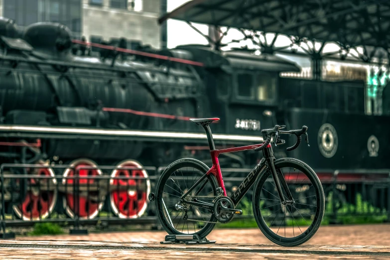 a bicycle parked in front of a train, pexels contest winner, black-crimson color scheme, render 8 k, thumbnail