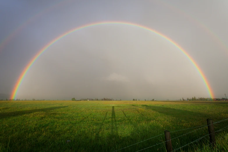 a couple of rainbows that are in the sky, an album cover, by Jan Rustem, unsplash, land art, yeg, panorama, hay, during a hail storm