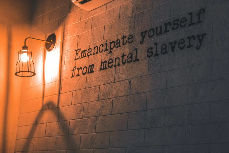 a light that is on the side of a building, by Emma Andijewska, pexels contest winner, graffiti, slave collar, motivational poster, in a hotel hallway, made of bronze