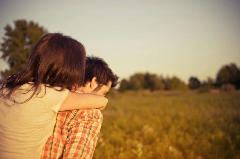 a couple of people that are standing in a field, pexels, romanticism, sweet hugs, retro stylised, over his shoulder, instagram post