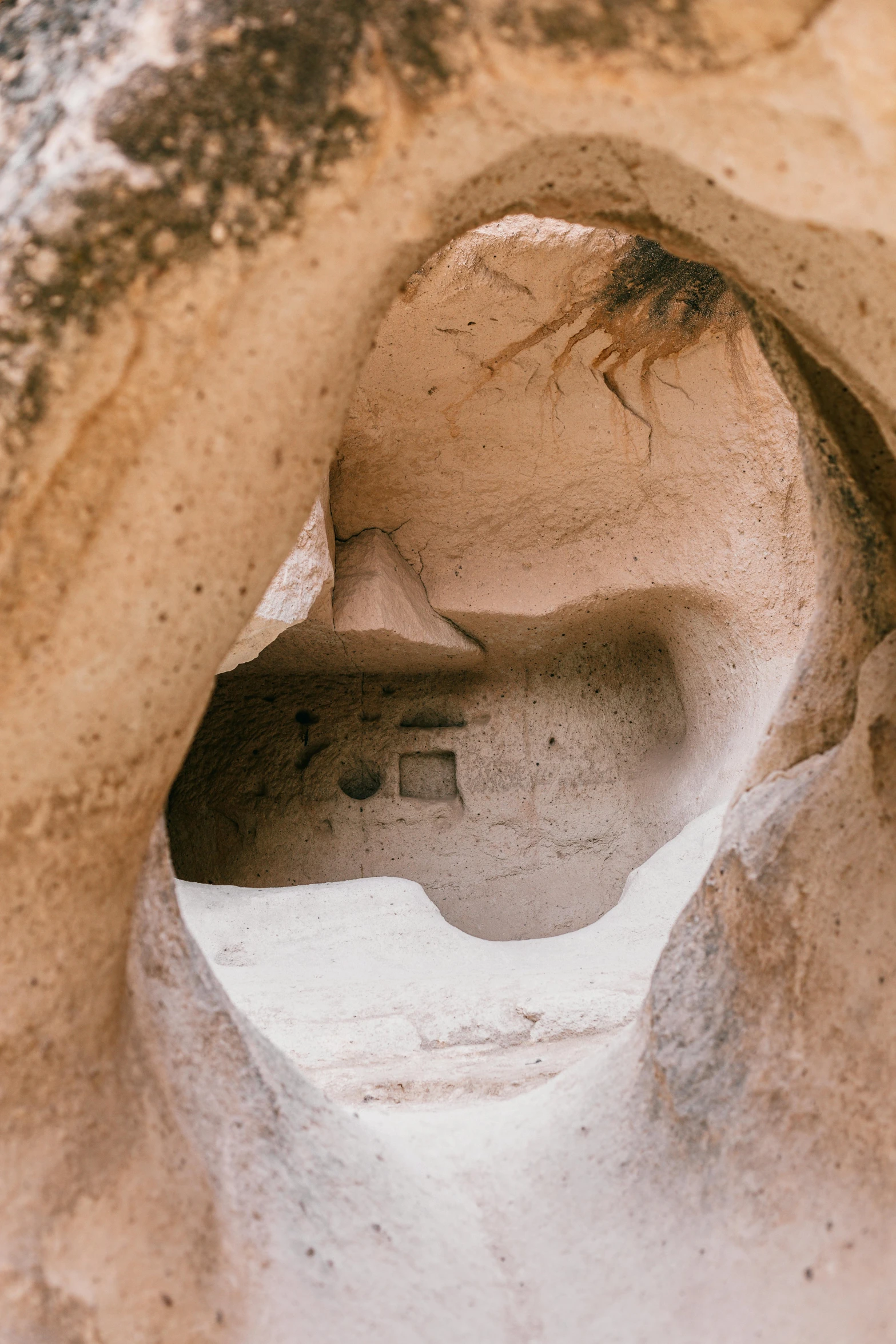 a close up of a rock with a hole in it, a cave painting, unsplash contest winner, art nouveau, sand - colored walls, wide high angle view, inside primitive hut, helmet view