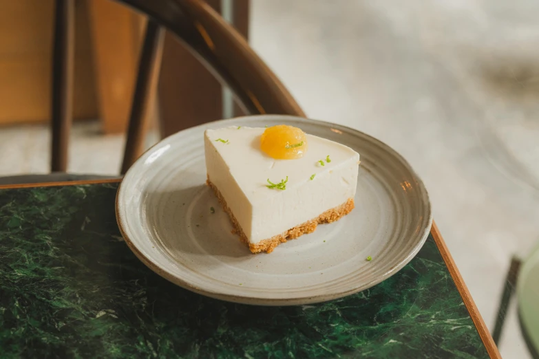 a piece of cheesecake on a plate on a table, unsplash, white soft leather model, bao pnan, citrinitas, 王琛