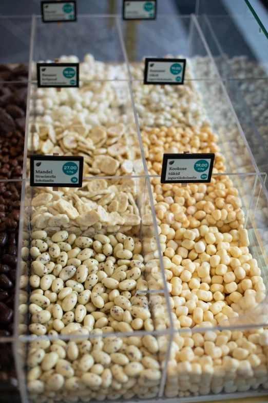 a display case filled with lots of different kinds of nuts, milk cubes, vanilla, white and teal metallic accents, thumbnail