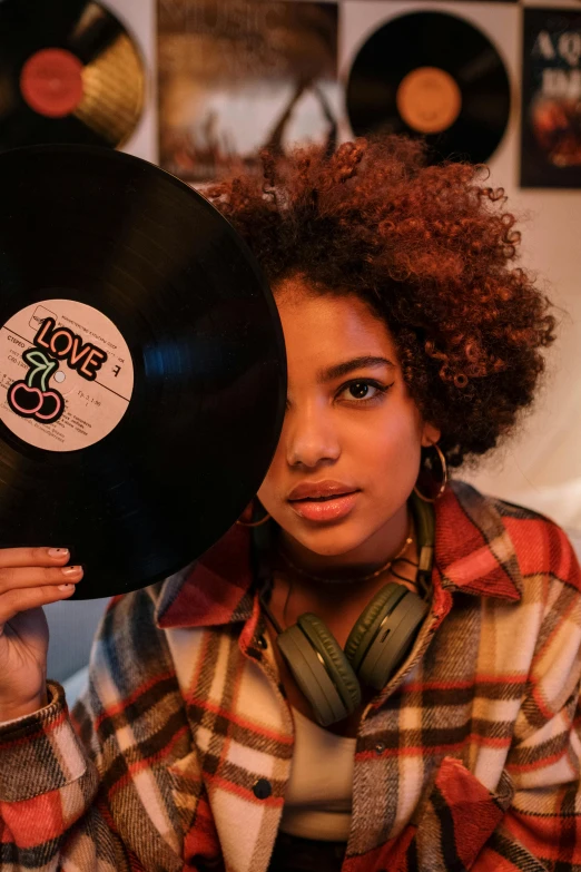 a woman holding a vinyl record in front of her face, an album cover, trending on pexels, funk art, big afro, love theme, profile image, dj at a party