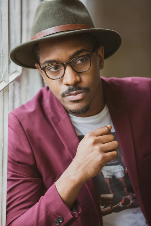 a close up of a person wearing a hat, a portrait, inspired by Gordon Parks, in suit with black glasses, young man in a purple hoodie, in a medium full shot, promotional image
