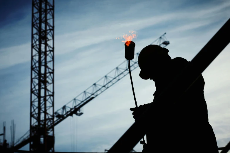 a silhouette of a man with a torch in his hand, pexels contest winner, constructivism, cranes, worksafe. instagram photo, profile image, thumbnail