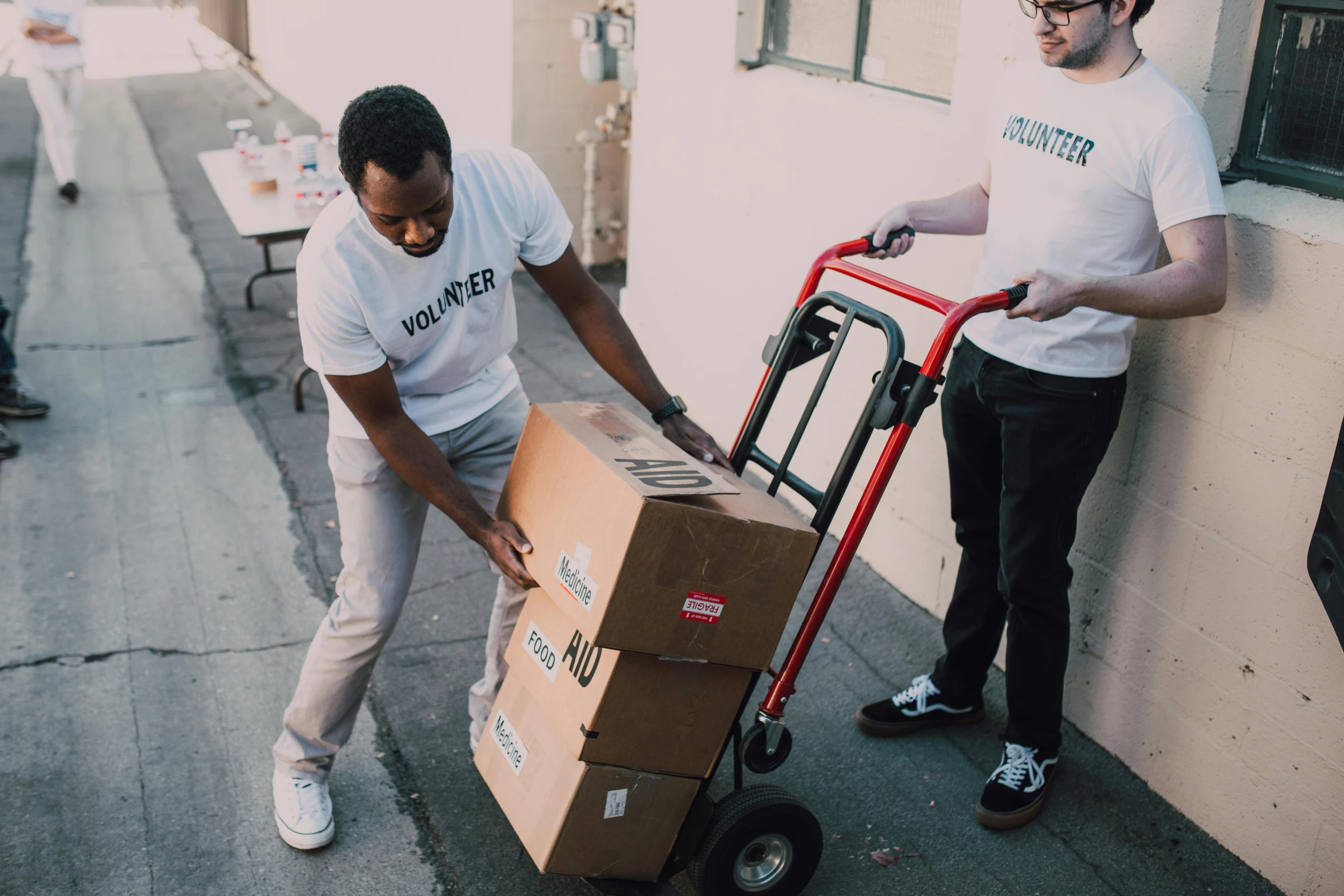 a man pushing a cart with a box on it, by Julia Pishtar, pexels contest winner, virgil abloh, vannessa ives, delivering parsel box, ::