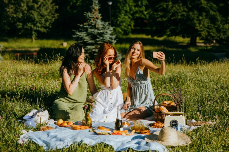 a group of women sitting on top of a lush green field, pexels contest winner, figuration libre, eating a cheese platter, taking selfies, 3 young and beautiful women, people on a picnic