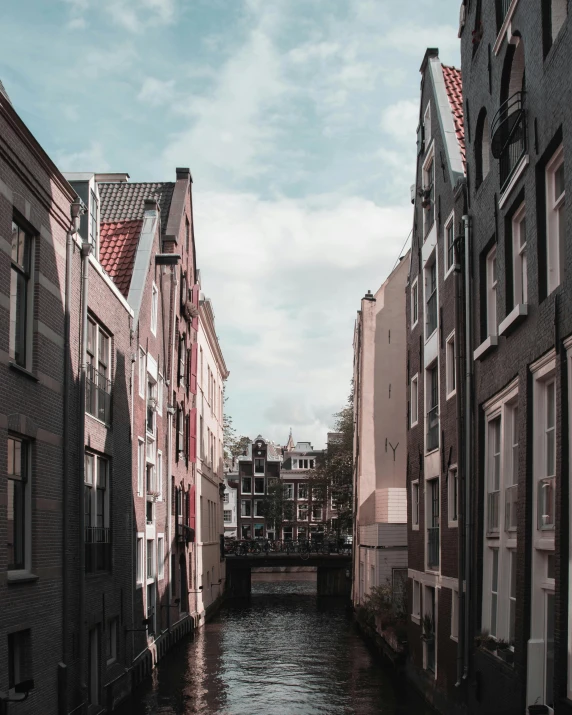 a river running through a city next to tall buildings, by Jacob Toorenvliet, view of houses in amsterdam, lgbtq, standing in an alleyway, trending on