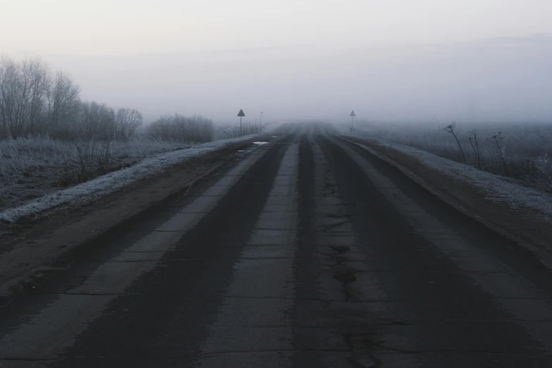 a dirt road in the middle of a foggy field, an album cover, by Attila Meszlenyi, pexels contest winner, postminimalism, icy cold pale silent atmosphere, highways, grey, tar roads