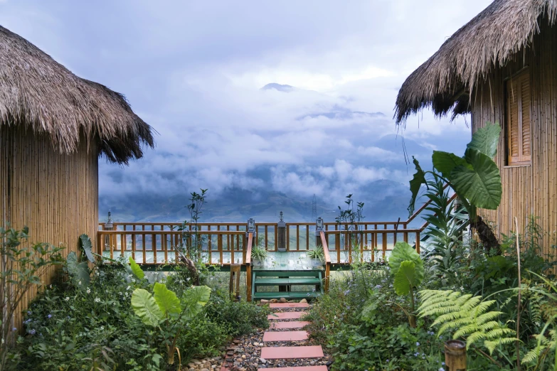 a couple of huts sitting on top of a lush green field, view above the clouds, plants and patio, profile image