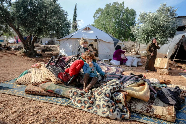 a group of people sitting on top of a blanket, hurufiyya, olive trees, tents, press photos, 15081959 21121991 01012000 4k