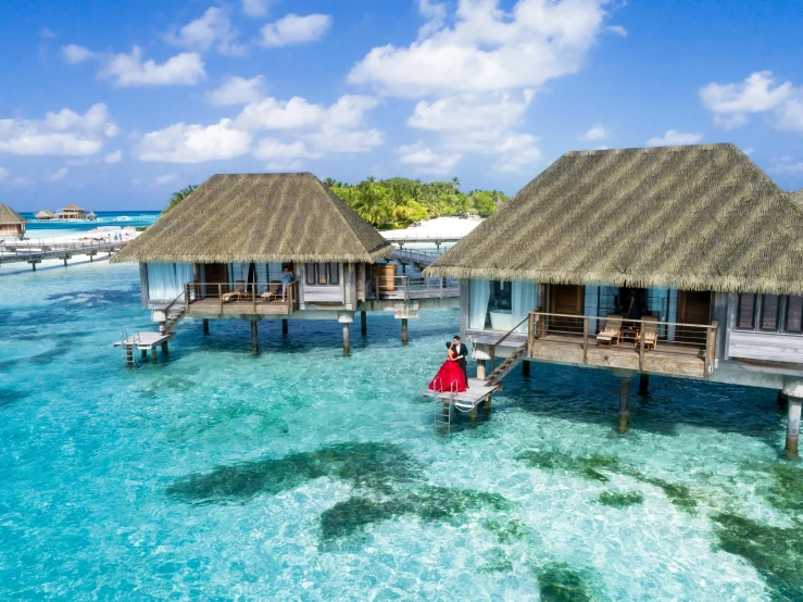 a couple of huts sitting on top of a body of water, coral reefs