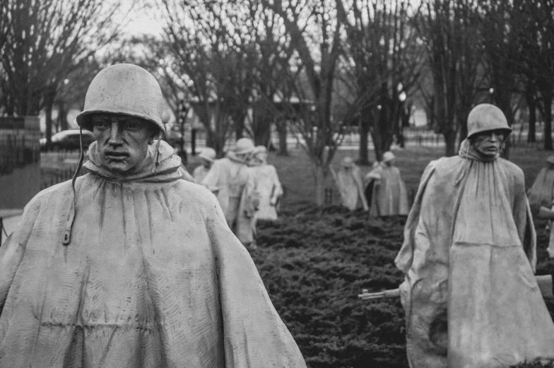 a black and white photo of a group of statues, by John Keane, korean war, medium shot of two characters, instagram photo, he is wearing a trenchcoat