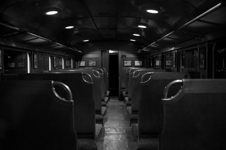 a black and white photo of a train car, a portrait, unsplash, dark classic interior, school class, with back to the camera, isolated