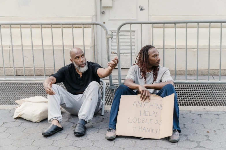 two men sitting next to each other on a sidewalk, pexels contest winner, renaissance, protesters holding placards, skilled homeless, black people, 9/11