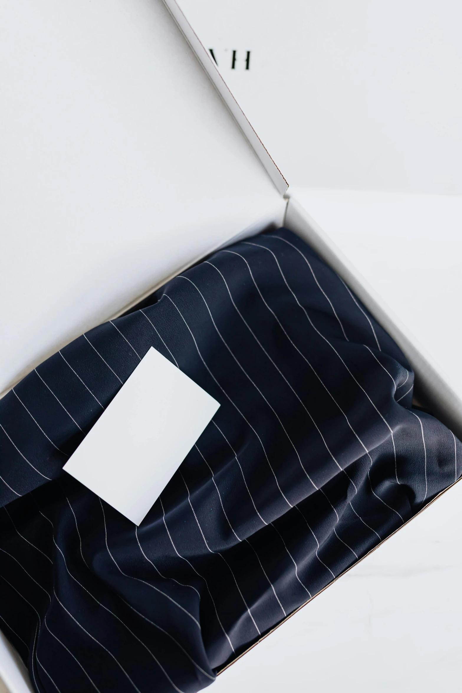 a box that has a piece of paper in it, by Eden Box, trending on unsplash, private press, pinstripe suit, fabrics and textiles, opening, on white paper