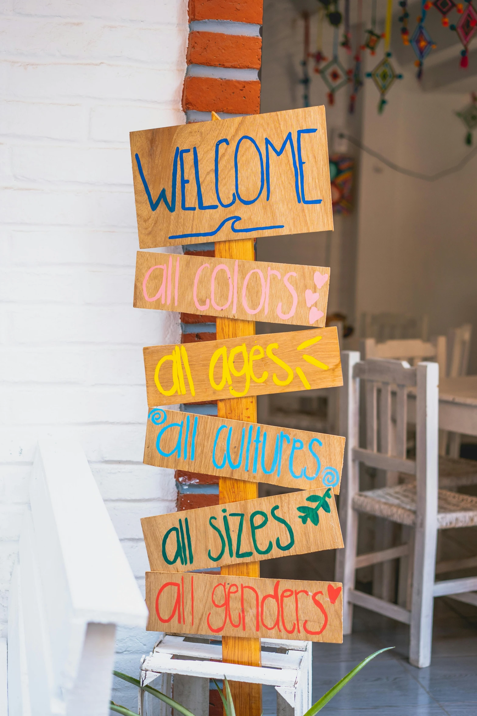 a wooden sign sitting on the side of a building, colorful adornments, indoor setting, well list, all colors