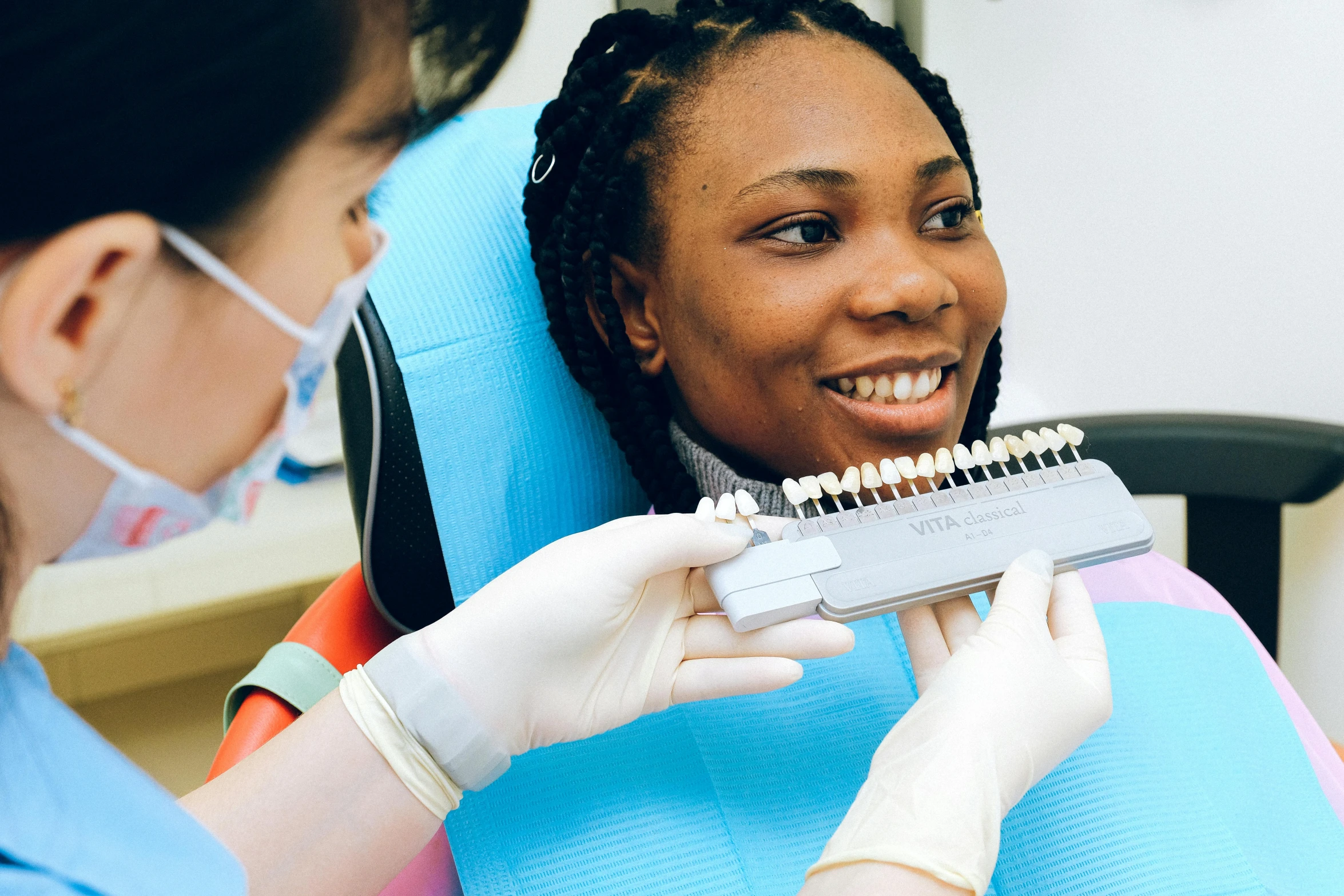 a woman sitting in a chair with a toothbrush in her mouth, by Joe Bowler, pexels contest winner, hurufiyya, uniform teeth, sterile colours, profile image, light skinned african young girl