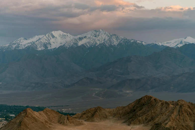 a person flying a kite on top of a mountain, by Peter Churcher, unsplash contest winner, hurufiyya, cinematic silk road lanscape, 4 k cinematic panoramic view, distant mountains lights photo, early evening