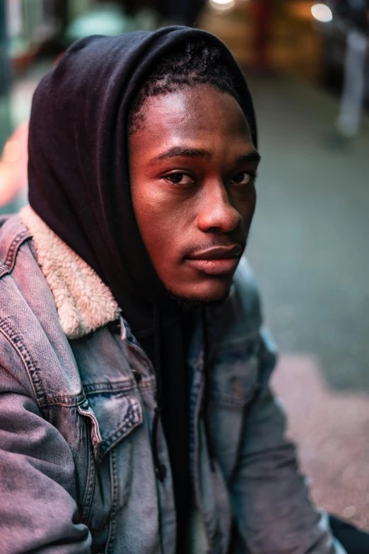 a man sitting on the ground wearing a hoodie, trending on pexels, renaissance, portrait close up of guy, ( ( dark skin ) ), wearing a turtleneck and jacket, androgynous person