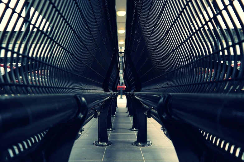 a couple of benches sitting next to each other, inspired by Andreas Gursky, unsplash, futurism, spaceship hallway, large pipes, looking up at the camera, datacentre