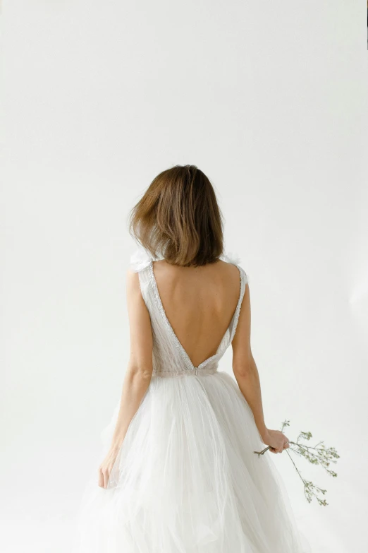 the back of a woman in a white wedding dress, inspired by Perle Fine, unsplash, light grey mist, 3 / 4 pose, front closeup, small