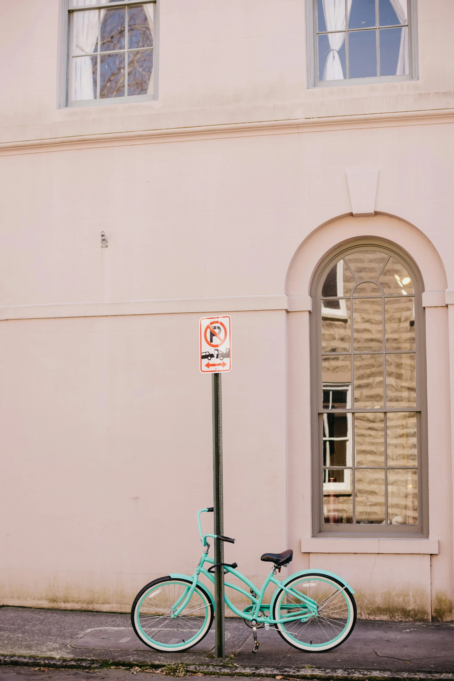 a blue bicycle parked in front of a pink building, by Nina Hamnett, trending on unsplash, postminimalism, stop sign, in savannah, low quality photo, light - brown wall