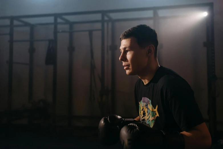 a man holding a pair of boxing gloves, a portrait, pexels contest winner, azamat khairov, profile image, in a gym, 20 years old